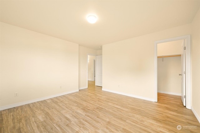 spare room with light wood-style flooring and baseboards