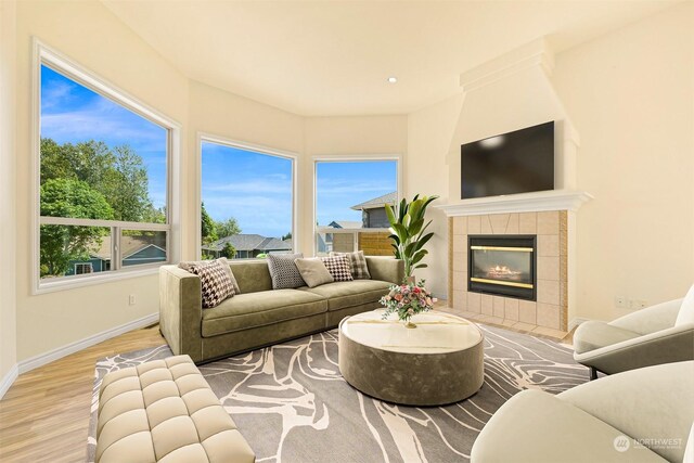 living room featuring wood-type flooring and a tile fireplace