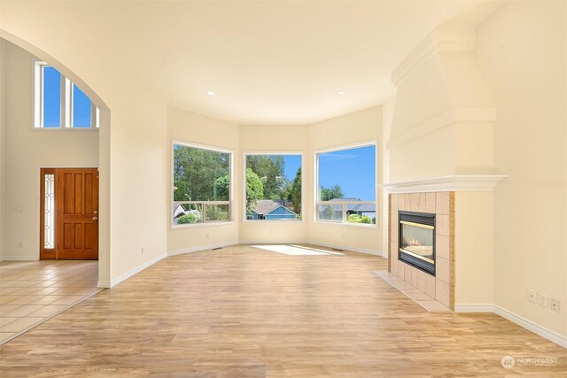 unfurnished living room featuring light hardwood / wood-style floors and a tile fireplace