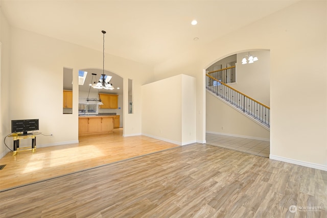 unfurnished living room featuring hardwood / wood-style flooring and an inviting chandelier