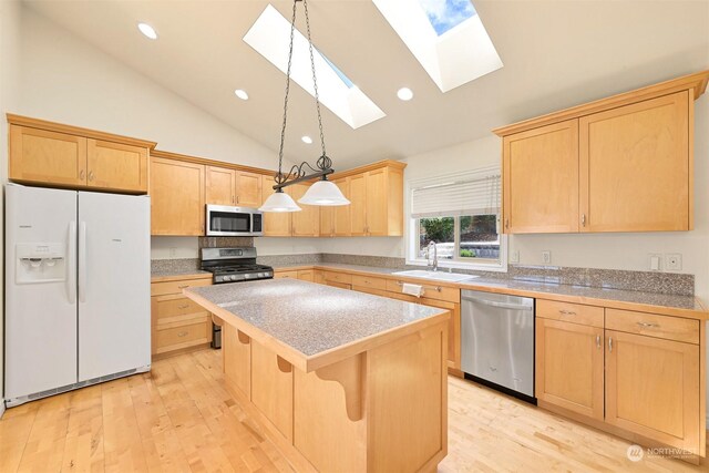 kitchen featuring light hardwood / wood-style floors, sink, appliances with stainless steel finishes, and a skylight