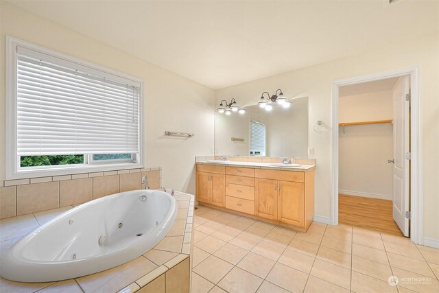 bathroom with tiled tub, vanity, and hardwood / wood-style floors