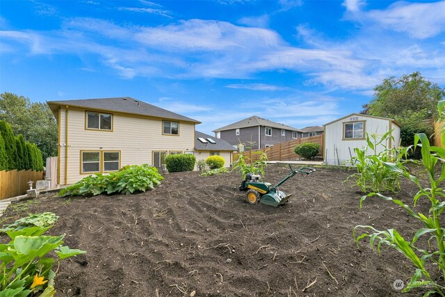 view of yard with a fenced backyard, an outdoor structure, and a shed