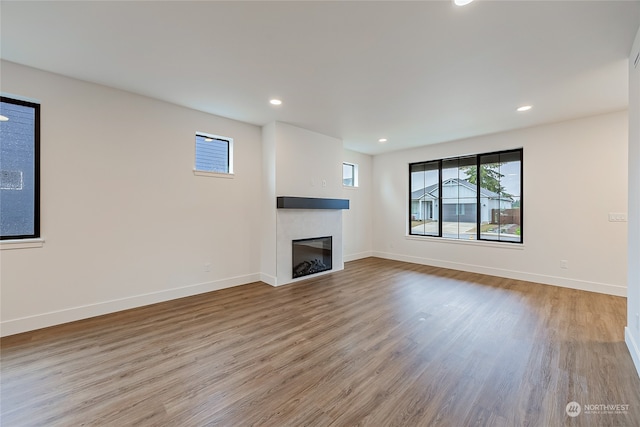 unfurnished living room featuring a fireplace and light hardwood / wood-style floors