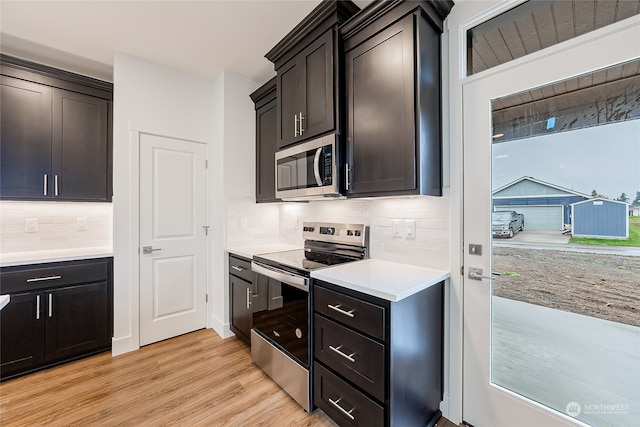 kitchen featuring decorative backsplash, stainless steel appliances, and light hardwood / wood-style flooring