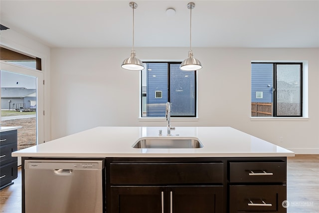 kitchen with stainless steel dishwasher, sink, light hardwood / wood-style flooring, and an island with sink