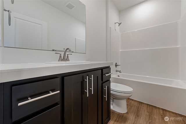 full bathroom featuring  shower combination, hardwood / wood-style flooring, vanity, and toilet