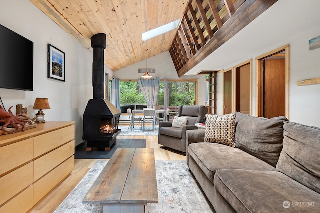 living room featuring light wood-type flooring, wood ceiling, a wood stove, and high vaulted ceiling