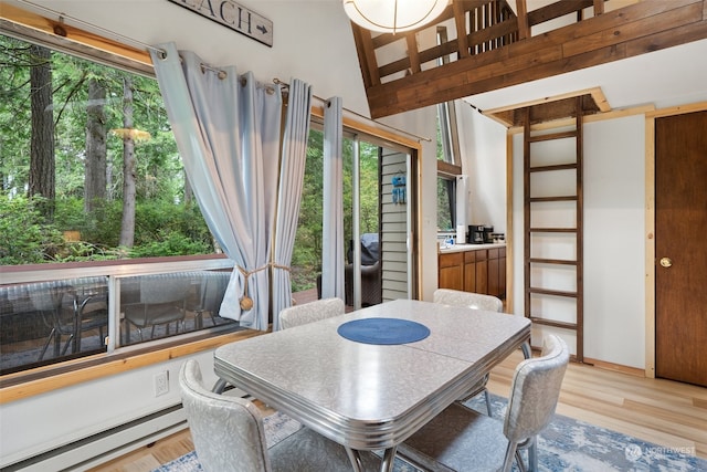 dining space featuring light wood finished floors and a baseboard radiator