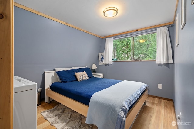 bedroom with light wood-type flooring and baseboards