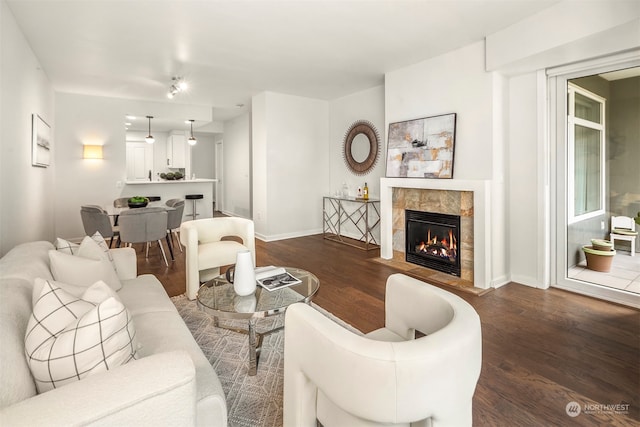 living room featuring dark wood-type flooring and a tiled fireplace