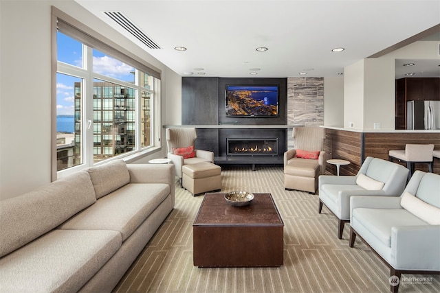 living room featuring a fireplace and light colored carpet