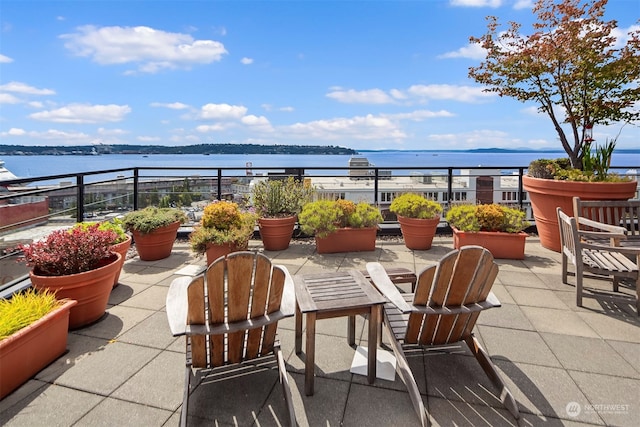 view of patio featuring a water view and a balcony