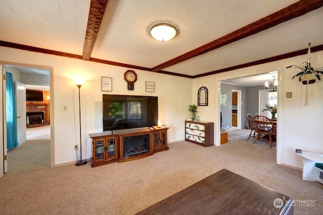 living room featuring a textured ceiling, carpet, a fireplace, and beamed ceiling