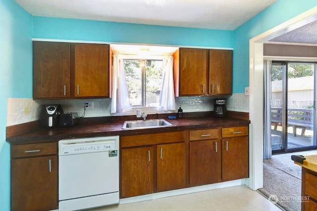 kitchen featuring dishwasher, tasteful backsplash, a sink, and a wealth of natural light