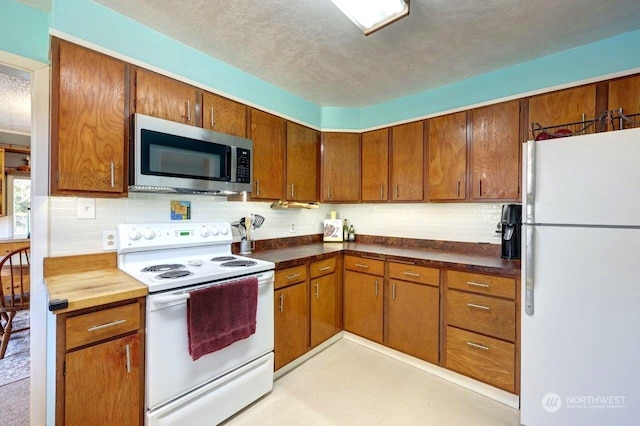 kitchen with white appliances, tasteful backsplash, and a textured ceiling