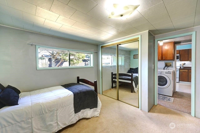 bedroom featuring a closet, carpet, and washer and dryer