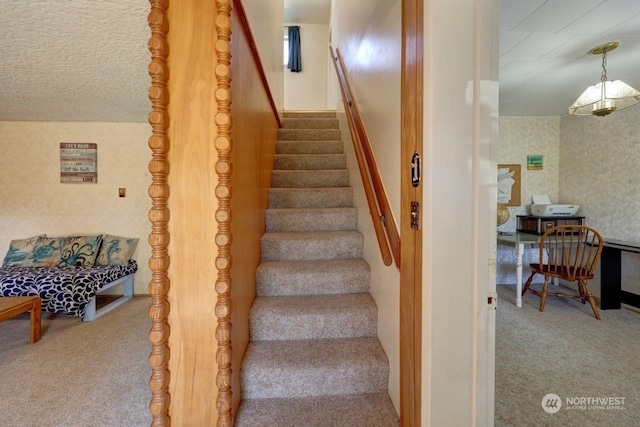 stairway featuring wallpapered walls and carpet flooring