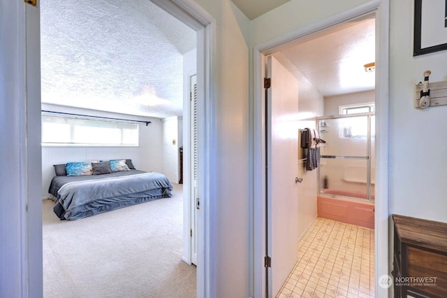 hall with a textured ceiling and carpet floors