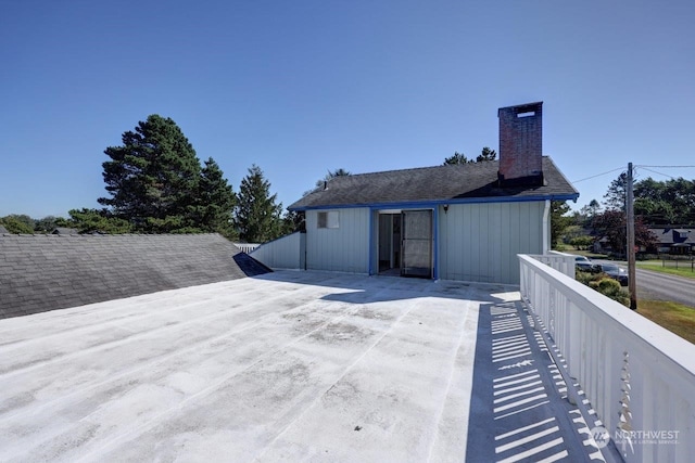 back of house with fence and a chimney