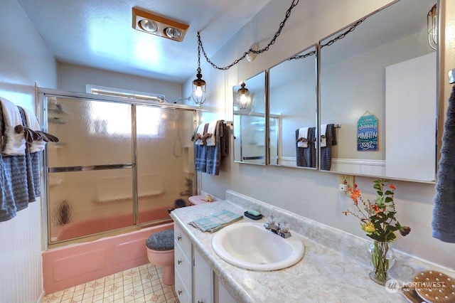 full bathroom with toilet, enclosed tub / shower combo, and vanity