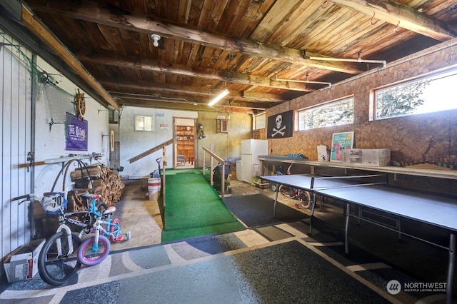 game room featuring a garage, wooden ceiling, and beam ceiling