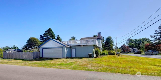 view of side of home featuring a garage, a yard, fence, and driveway