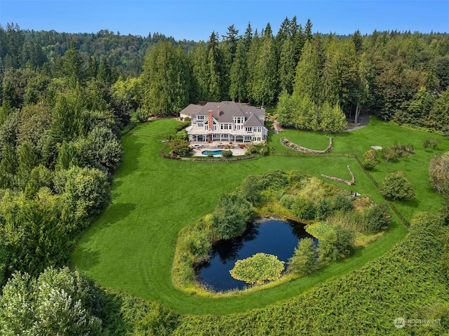 drone / aerial view with a water view and a forest view