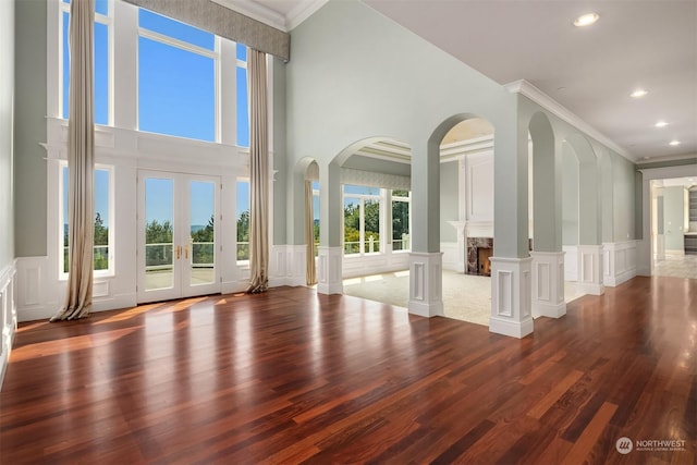 unfurnished living room with crown molding, a fireplace, a decorative wall, and wood finished floors