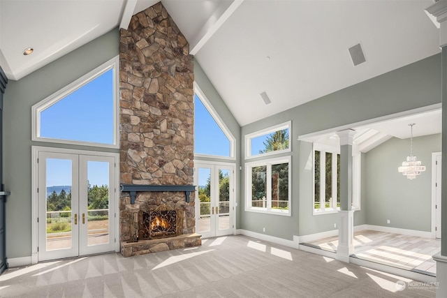 unfurnished living room with high vaulted ceiling, carpet flooring, and french doors