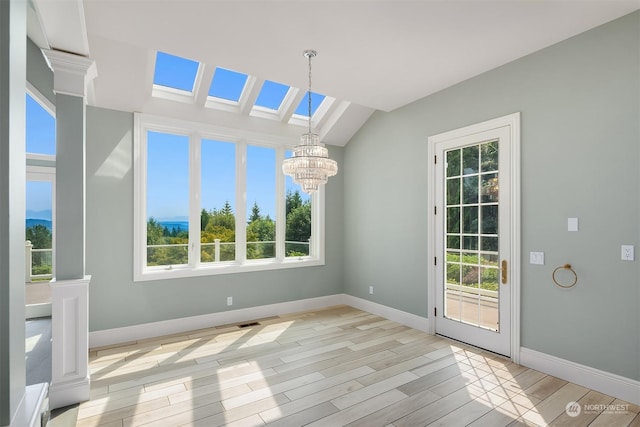 interior space featuring lofted ceiling, baseboards, light wood finished floors, and an inviting chandelier