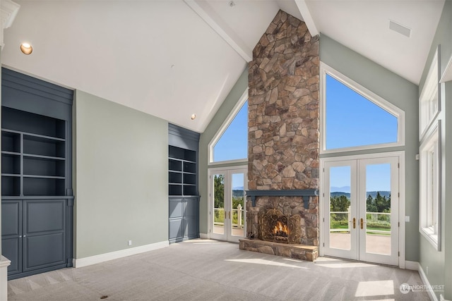 unfurnished living room with carpet floors, built in shelves, french doors, visible vents, and baseboards