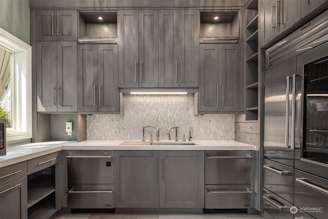 kitchen featuring open shelves, built in fridge, and light countertops