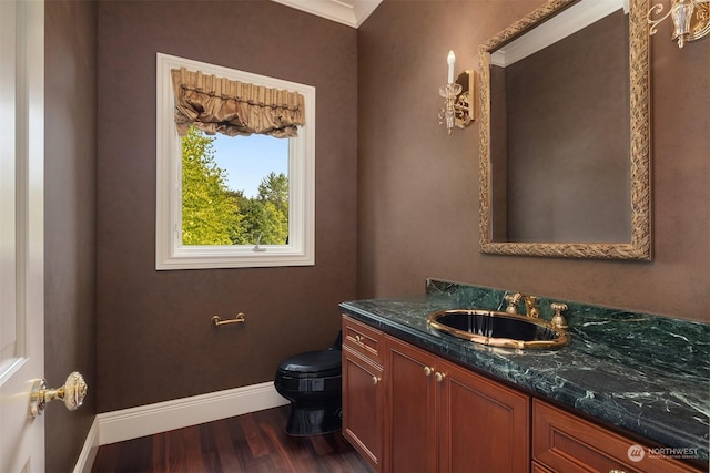 bathroom with toilet, baseboards, wood finished floors, and vanity