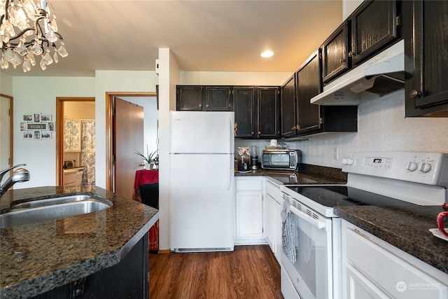 kitchen featuring dark stone countertops, white appliances, an inviting chandelier, sink, and dark hardwood / wood-style floors