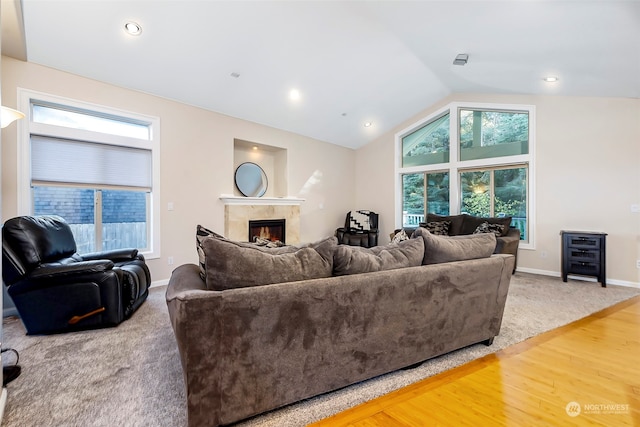 living room featuring a premium fireplace, lofted ceiling, and hardwood / wood-style flooring