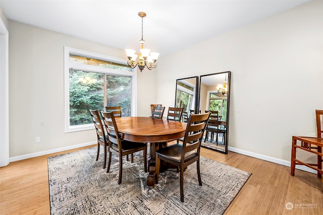 dining space with hardwood / wood-style flooring and an inviting chandelier