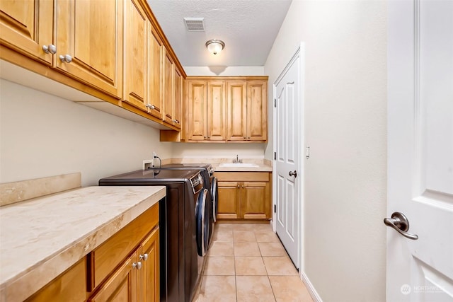 1001 Lakeview Dr, Ilwaco, WA 98624 - laundry room with washer and clothes dryer, cabinet space, light tile patterned floors, and a textured ceiling