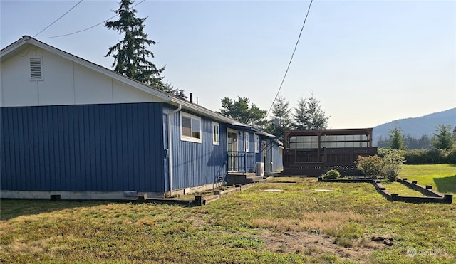 view of home's exterior featuring a lawn and a mountain view