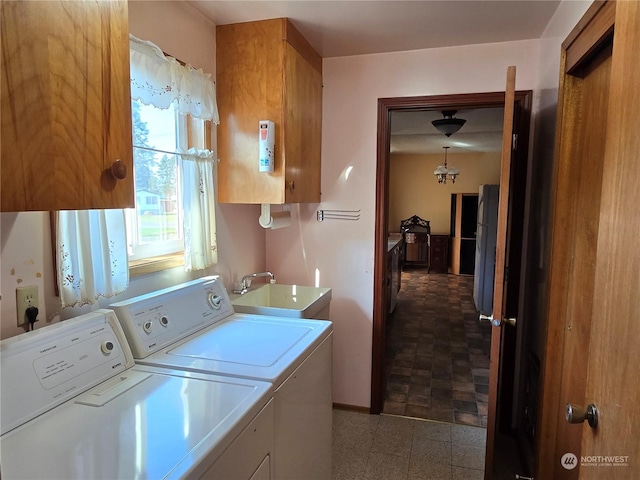 clothes washing area featuring independent washer and dryer, cabinet space, and a sink