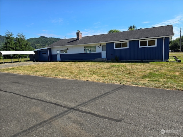 ranch-style house featuring a front yard and a carport