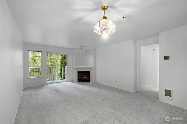 unfurnished living room with light colored carpet and a tiled fireplace