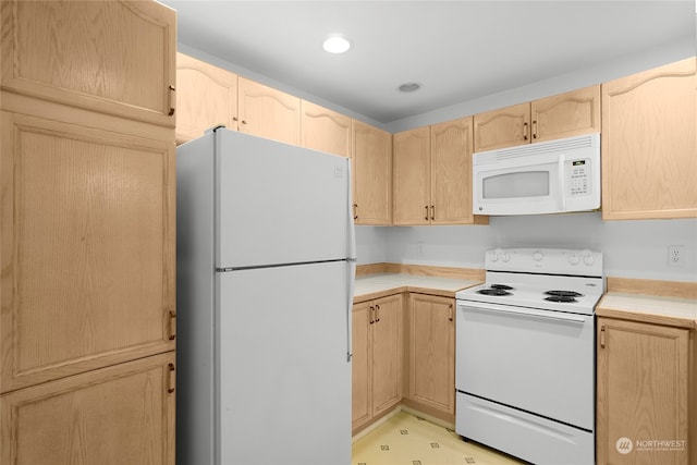 kitchen featuring light brown cabinetry and white appliances