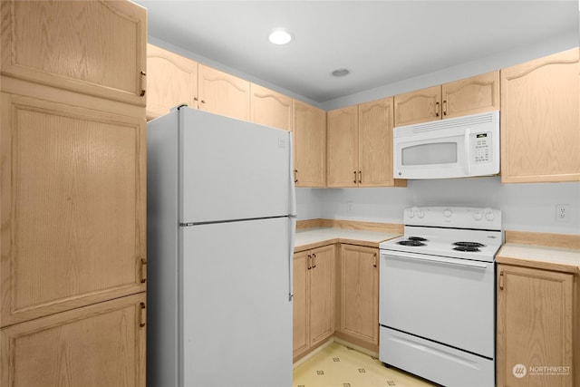 kitchen featuring light countertops, light brown cabinets, white appliances, and recessed lighting