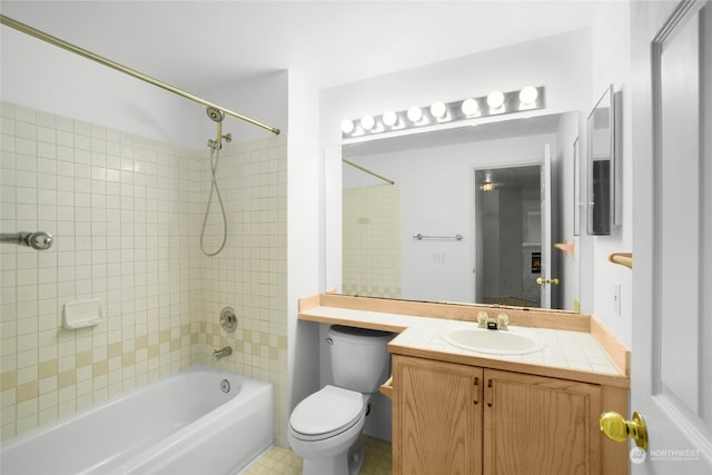 full bathroom featuring tile patterned flooring, toilet, vanity, and tiled shower / bath