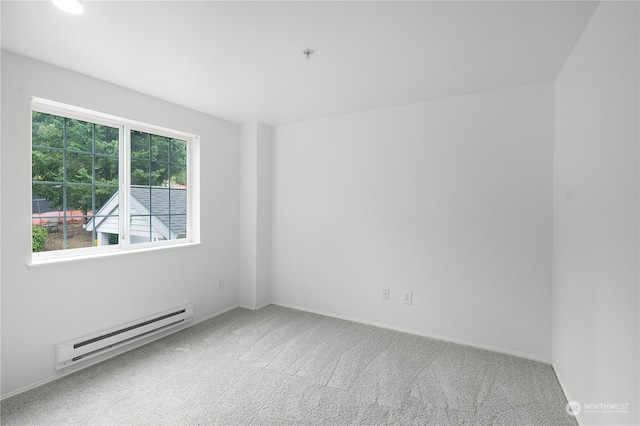 empty room with carpet flooring and a baseboard radiator