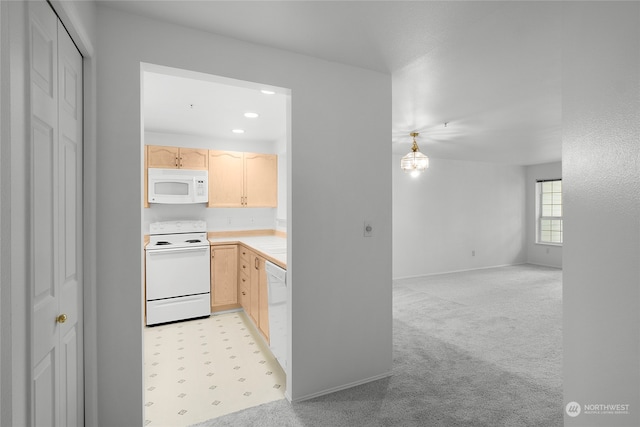 kitchen with light brown cabinets, white appliances, and light colored carpet