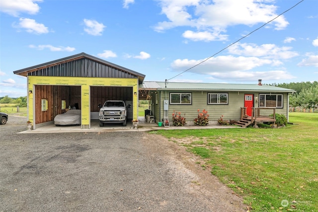 view of front facade featuring a garage, metal roof, and a front lawn