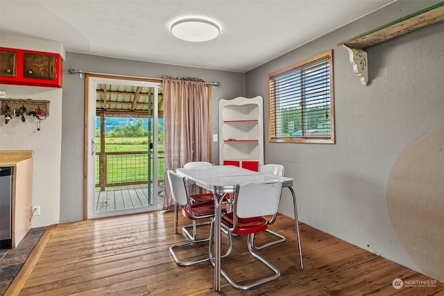 dining room featuring hardwood / wood-style floors and a textured wall