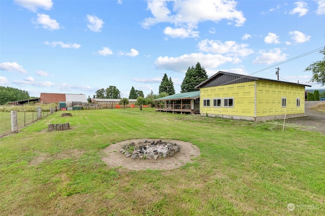 view of yard featuring an outdoor fire pit and fence